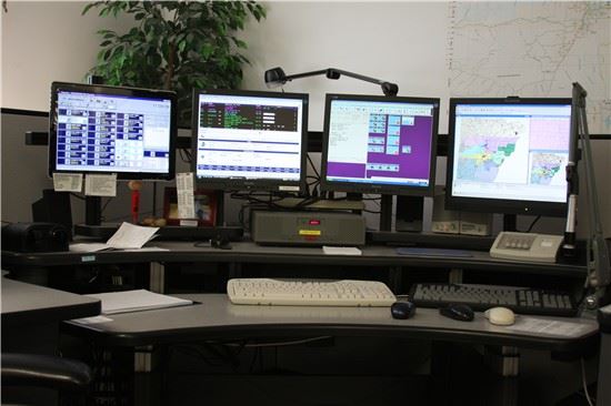 Image of 911 dispatch center desk with four screens